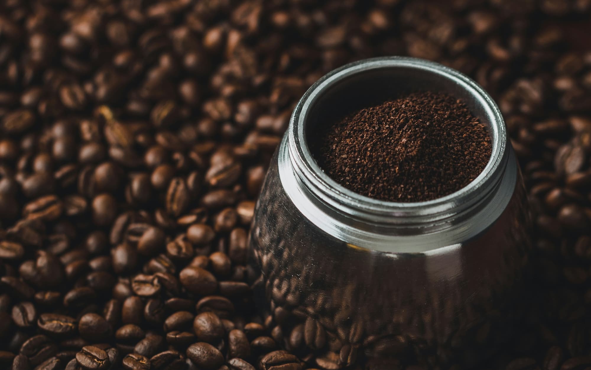 Dark roasted coffee are shown with a canister of ground dark roast coffee.